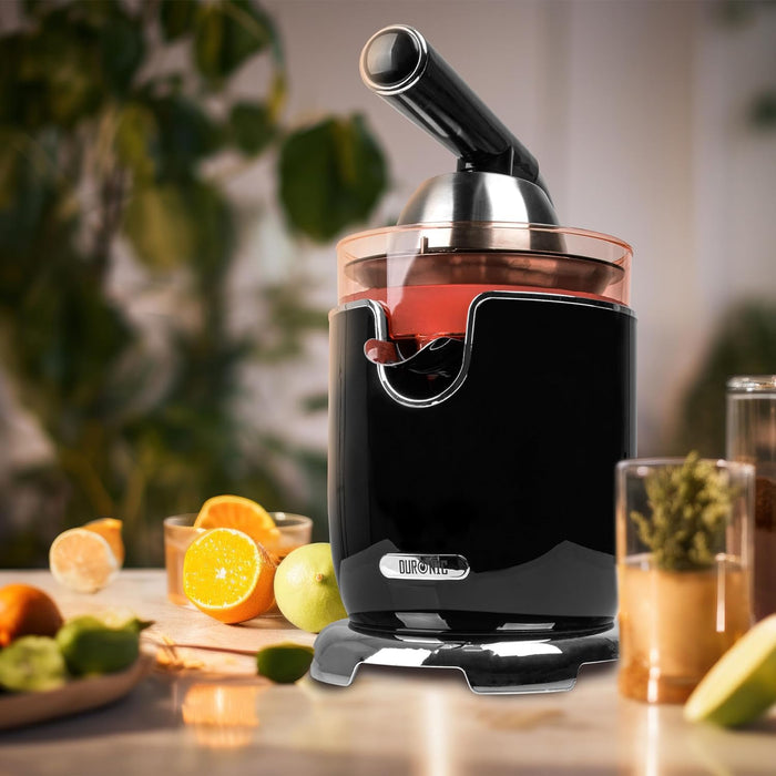 Duronic JE605 Saftpresse steht auf einem Tisch Früchte herum